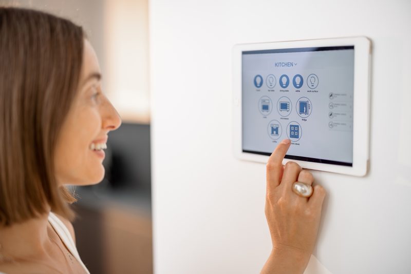 Homeowner using a smart home touchscreen to control lighting in a Tucson luxury home installed by Onora Systems